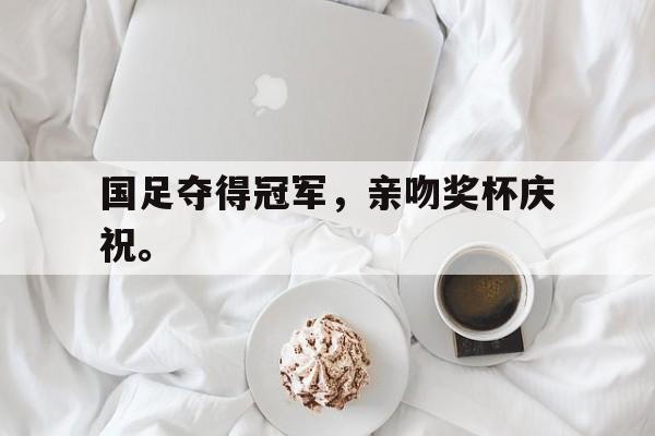 国足夺得冠军，亲吻奖杯庆祝。